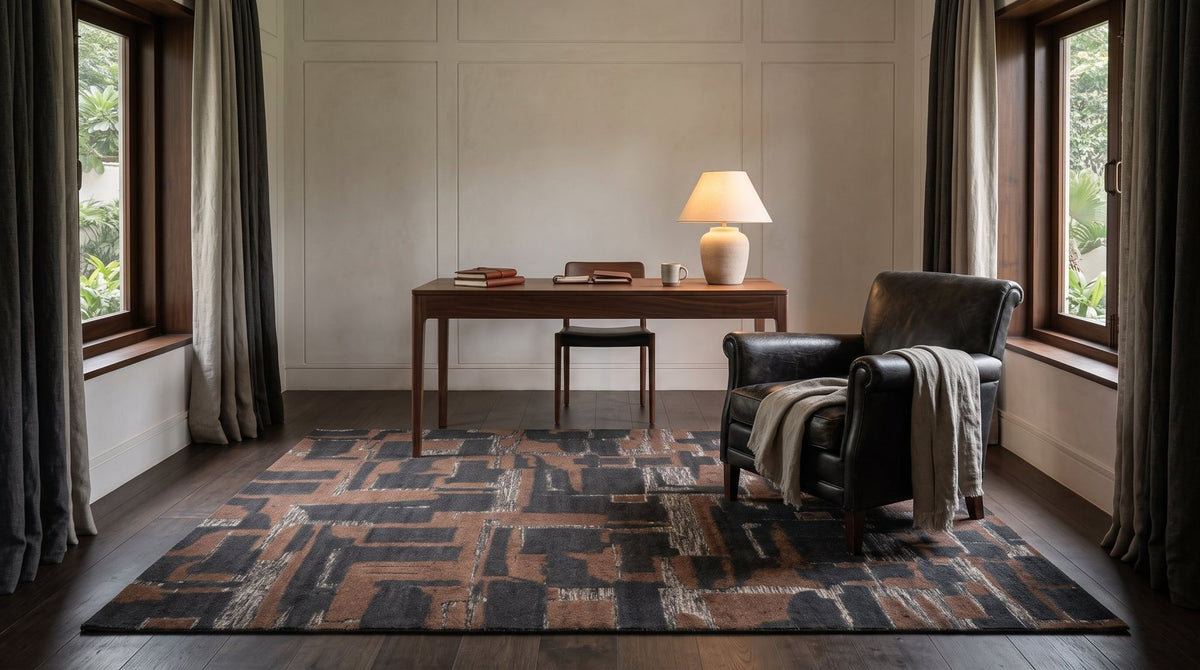 Stratum Knotted Rug in Cinder in a styled study, a hand knotted pile in charcoal, rust and grey.