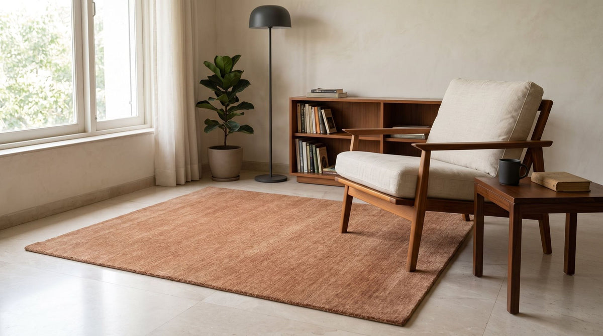 Grain Wool Rug in Russet in a styled reading corner, handloom New Zealand wool in a warm earth tone.