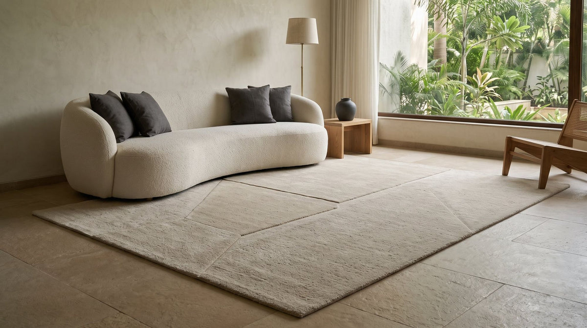 Cadence Wool Rug in a styled living room on a stone floor, hand tufted New Zealand wool with carved bands.