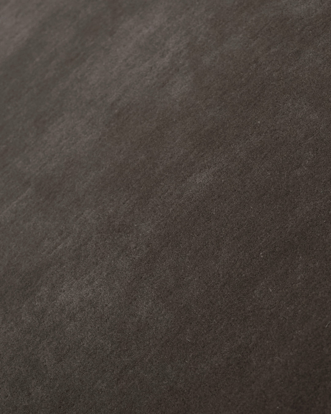 Close-up of the soft, textured surface of a hand-tufted taupe ombré rug, showcasing refined craftsmanship.